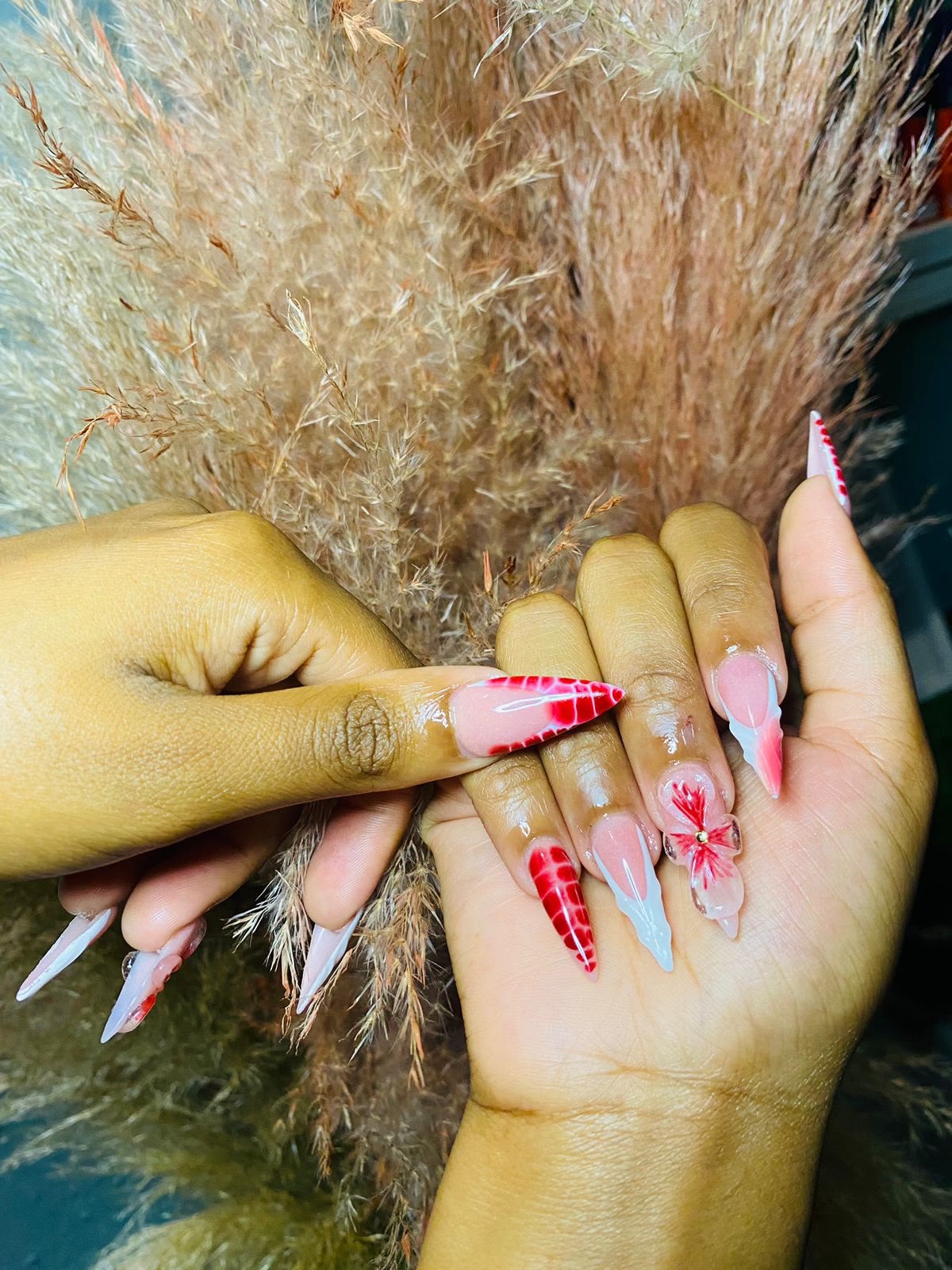 Red floral nail art created at Bubbles Beauty Bar