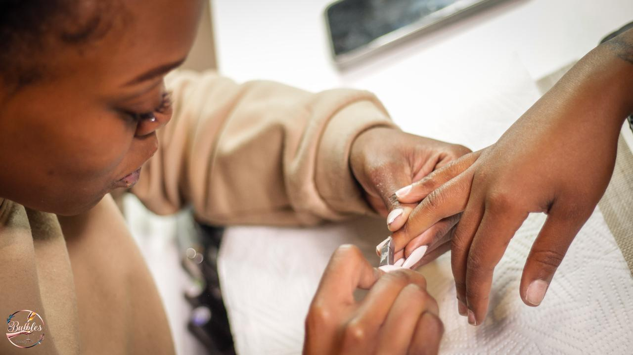 Nhlanhla performing a nail service for a client at Bubbles Beauty Bar